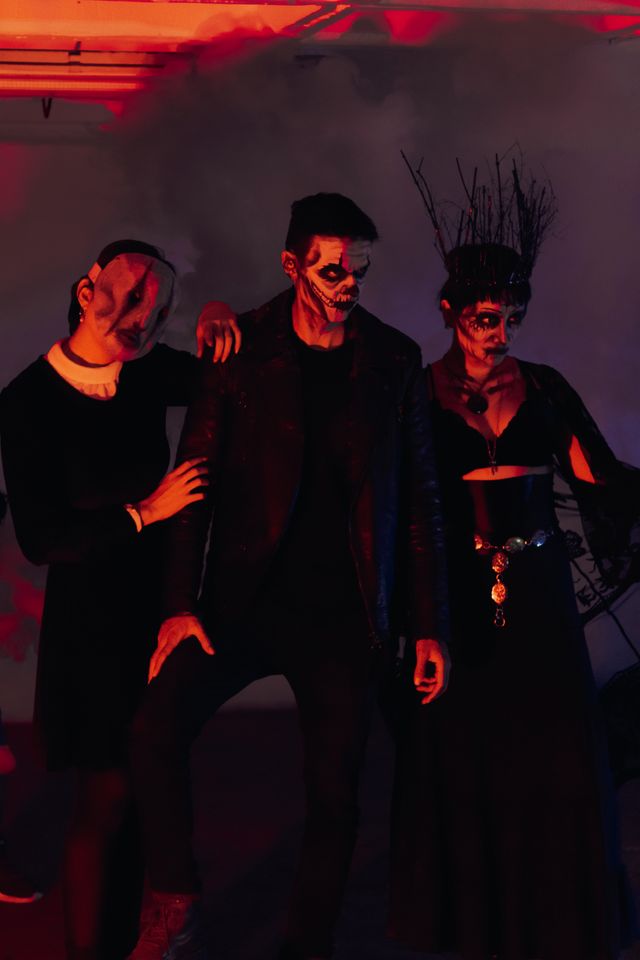 3 friends dressed up for halloween in a trio of matching halloween costumes for adults.