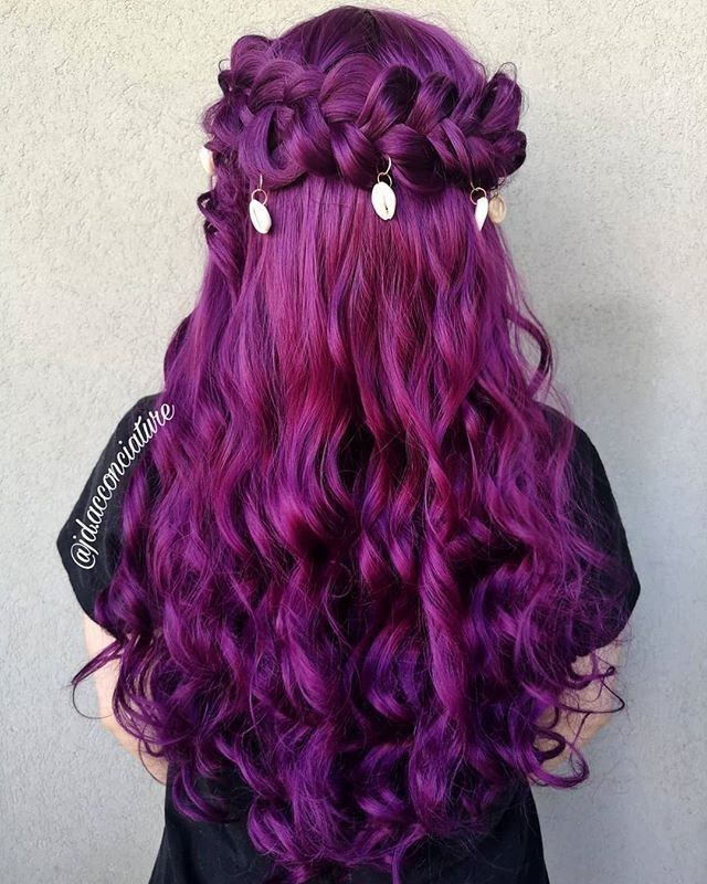 The back of a woman's head showing a whimsigoth prom hairstyle in bright magenta with a crown braid and shell charms.