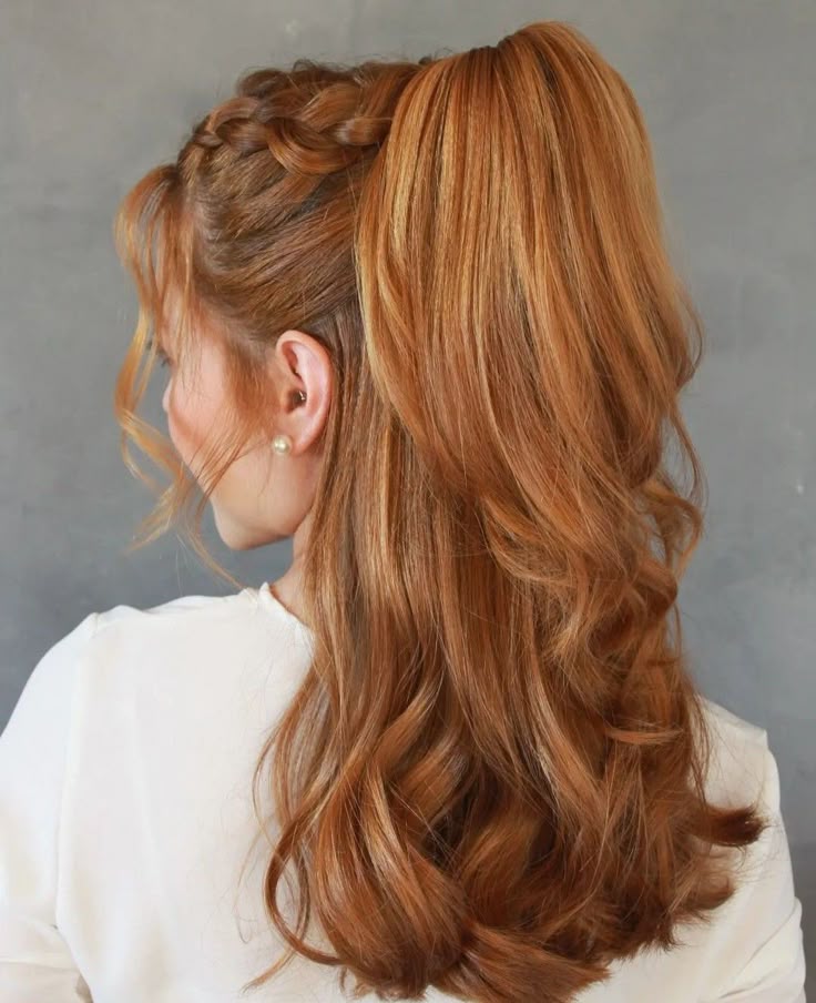 A side profile of a woman with copper-red hair featuring a Dutch braid along the side that gathers into a thick, high ponytail with soft waves.
