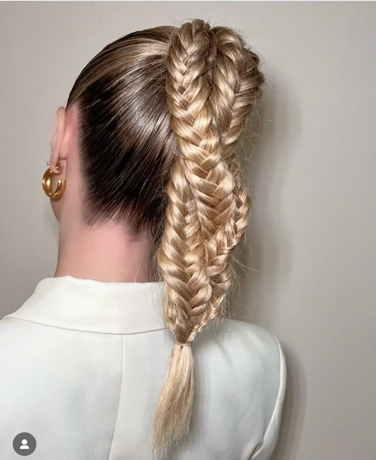 A back view of a person with light blonde hair in a high ponytail that is split and woven into a wide, chunky double fishtail braid.