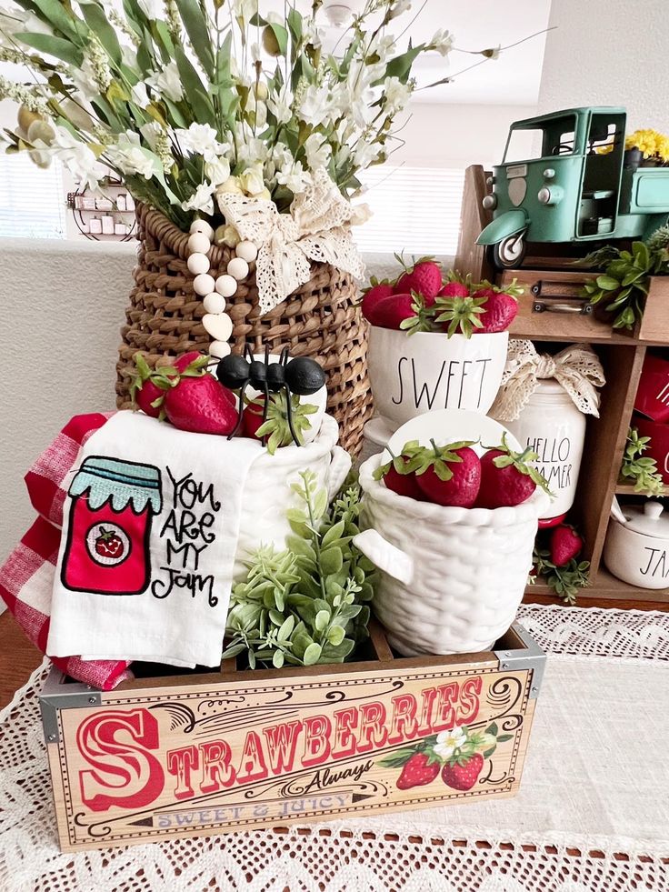 A farmhouse kitchen display featuring a strawberry decor wooden crate and berry-themed towels.