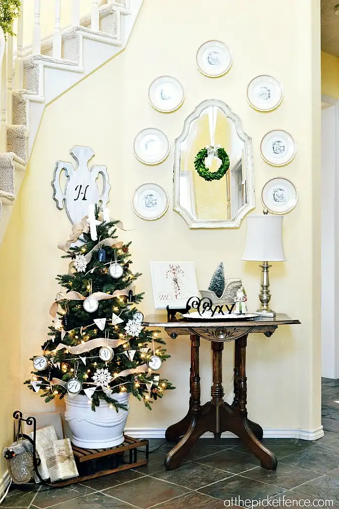 Elegant entryway winter decor idea with mini Christmas tree and plate wall display