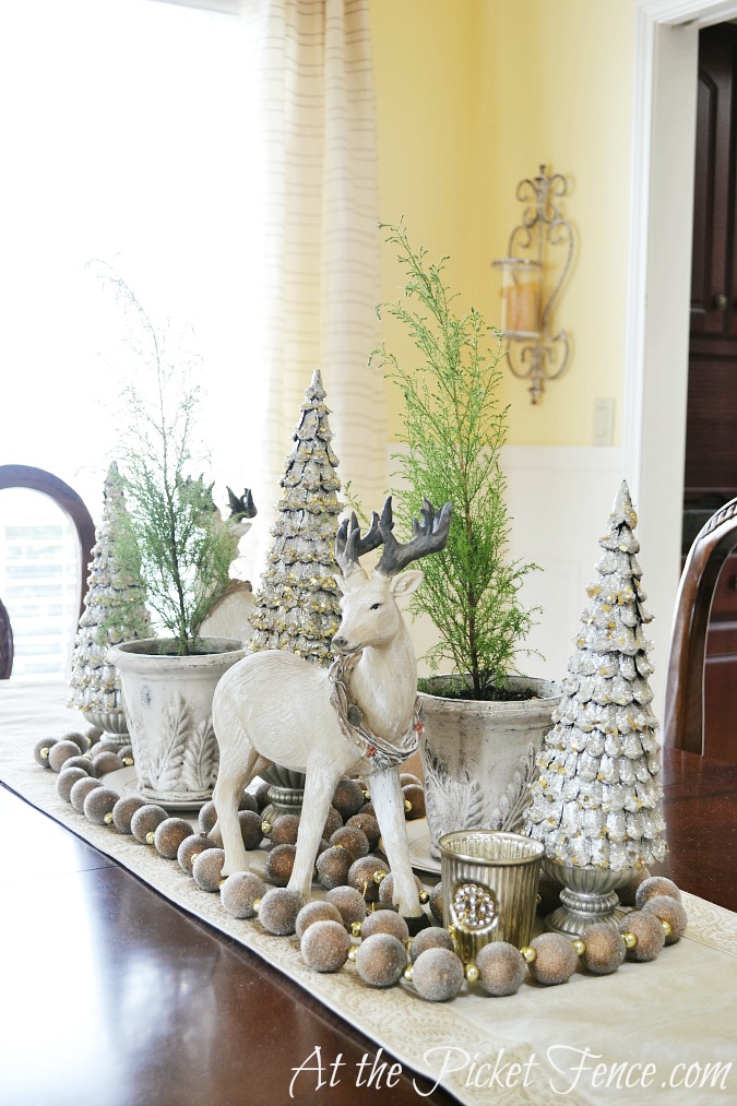 Woodland winter tablescape idea with reindeer figurine and bottle brush trees