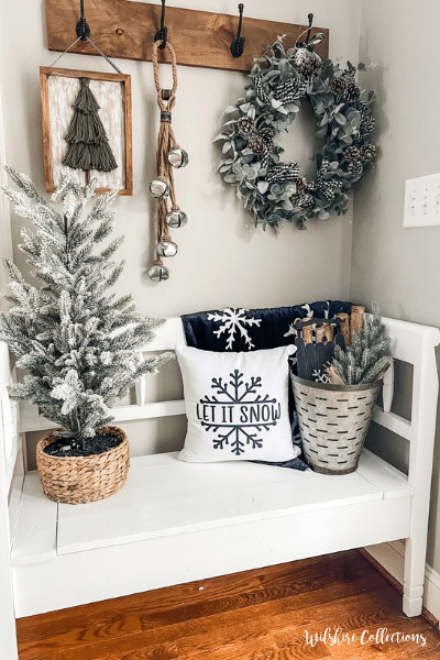Cozy entryway winter decor idea with flocked tree and snowflake pillow