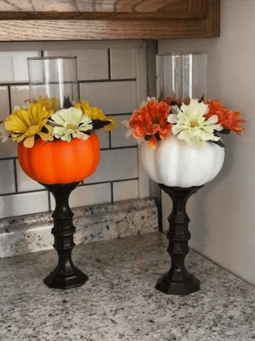DIY dollar store fall centerpiece idea with pumpkin candle holders and faux flowers