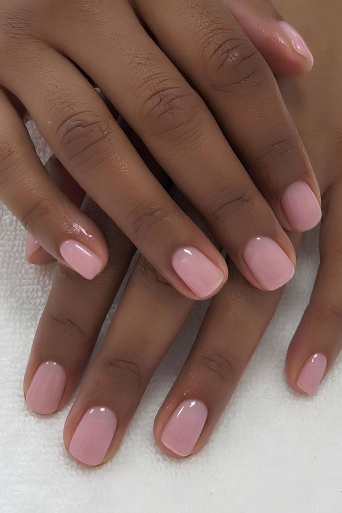 Short soft pink nails with a glossy jelly finish, short light pink nails in a sheer bubblegum pink polish, short square nails with a high-shine top coat, natural looking short pink manicure, simple short nail design, gel nails, sheer pink nails, glazed pink nails, easy everyday nails