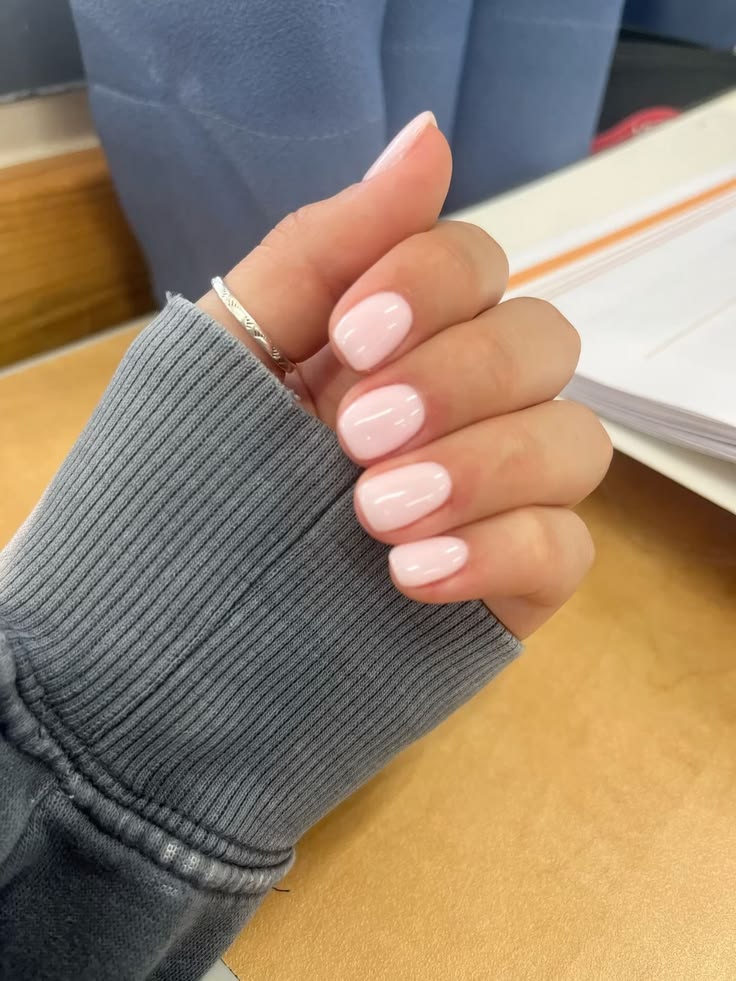 Short light pink nails with a glazed finish, short soft pink nails in a baby pink polish, short milky pink nails with high shine, short round nails, soft pink manicure, glossy pink nails, everyday nails, low maintenance nails, gel polish