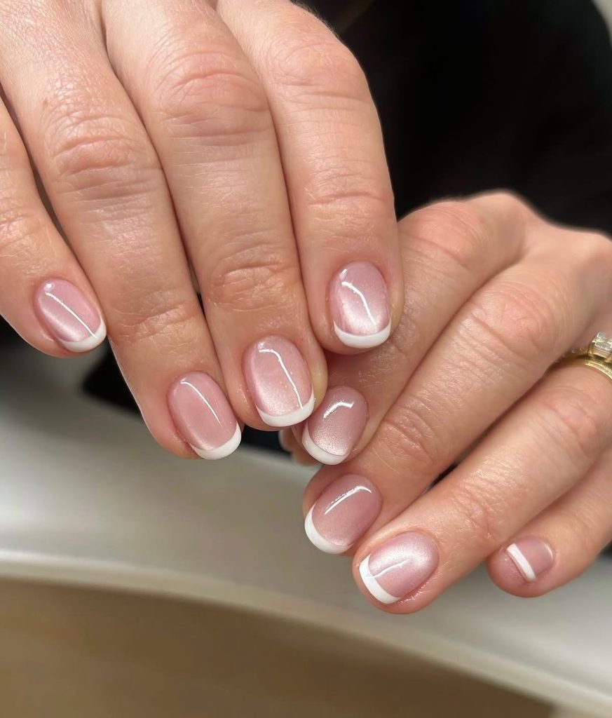 Short pink cat eye nails with white French tips, short soft pink nails with a velvet shimmer, short light pink nails with magnetic gel polish, pink cat eye French manicure, short round nails, shimmery pink nails, velvet nails, white tip nails, gel nails